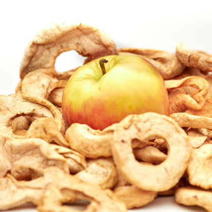 NESSLIM Apfelscheiben neben frischem Apfel als praktischer Snack für Lunchbox, Schule und unterwegs.