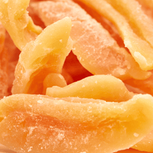 Nahaufnahme gezuckerter Cantaloupe-Melonenstreifen mit feinen Zuckerkristallen auf orangefarbenen, geschwungenen Fruchtstücken.