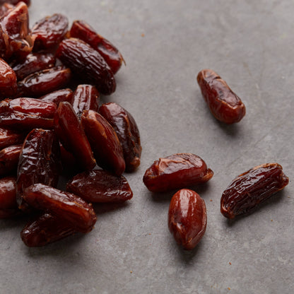 Deglet Nour Datteln auf Marmorplatte als aromatischer Fruchtsnack für die kleine Pause.