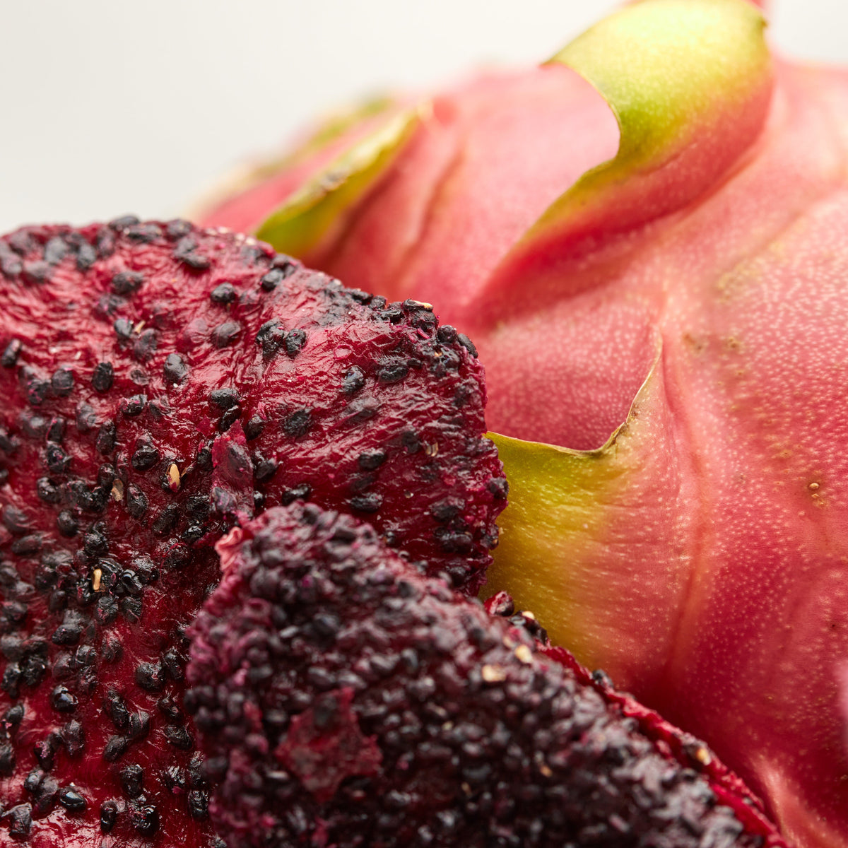 Getrocknete NESSLIM Drachenfrucht neben frischer Pitahaya – naturbelassener Snack ohne Zusätze.