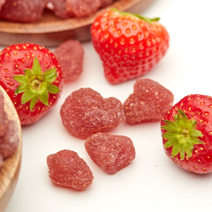 Kandierte Erdbeeren von NESSLIM neben frischen Erdbeeren als farbenfrohes Topping für Joghurt, Müsli, Quark und Bowls.