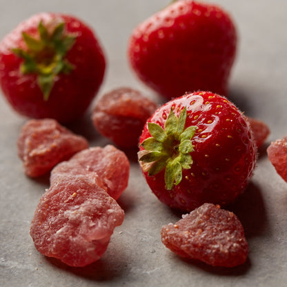 Kandierte Erdbeeren von NESSLIM mit frischen Erdbeeren auf grauer Marmorplatte zum Backen und für Dessertgläser.