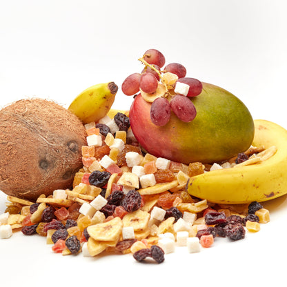 Exotische Früchtemischung Tropic Mix von NESSLIM mit Trockenfrüchten, Kokosstücken und Bananenchips neben Mango und Kokosnuss.