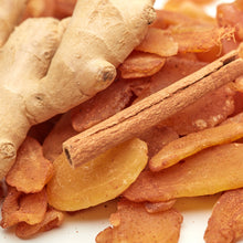 Kandierte Ingwerscheiben mit Zimt neben frischer Ingwerwurzel und Zimtstange – würzig-süße Zutat für Tee, Kuchen und Plätzchen.