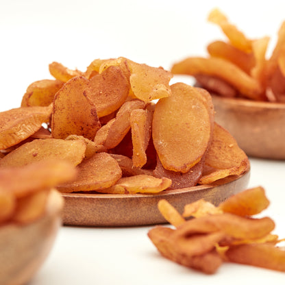 Kandierte Ingwerscheiben mit Zimt von NESSLIM in Holzschalen als süß-scharfer Snack zur Teezeit und für gemütliche Genussmomente.