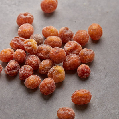 Kandierte Kumquats von NESSLIM auf grauer Marmorplatte zum Backen und für kreative Küche.