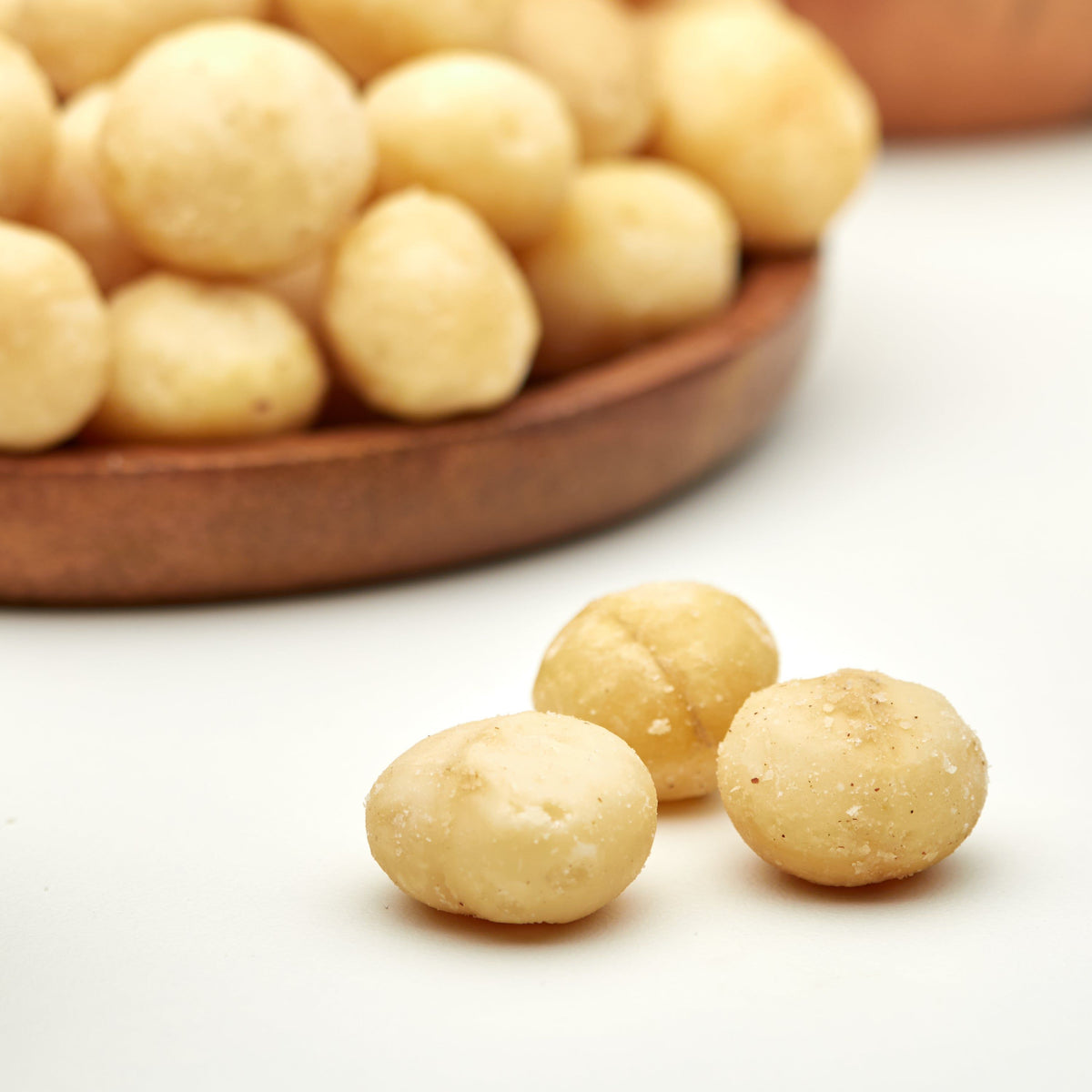 Geroestete Macadamias in der Snackschale zum Aperitif mit Wein
