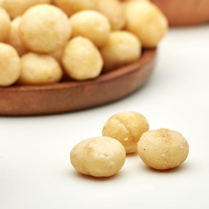 Geroestete Macadamias in der Snackschale zum Aperitif mit Wein