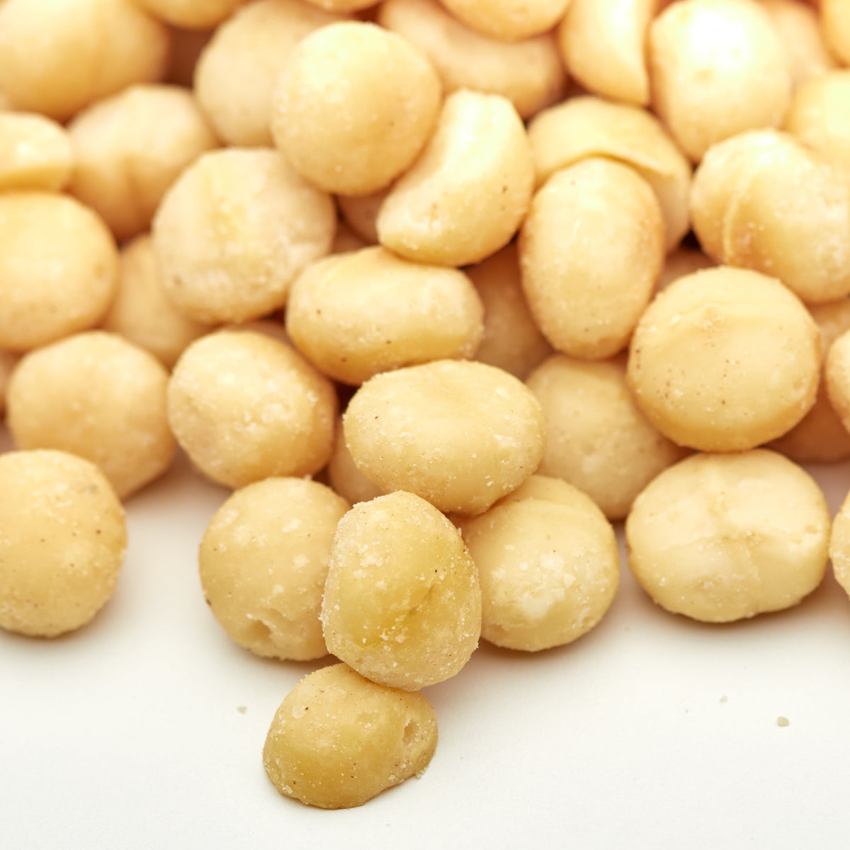 Macadamia-Kerne geroestet auf einer Kaeseplatte