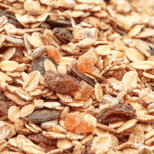 Makroaufnahme des Premium Müslis von NESSLIM mit Haferflocken, Kürbiskernen, Sonnenblumenkernen, Sultaninen und Papaya.
