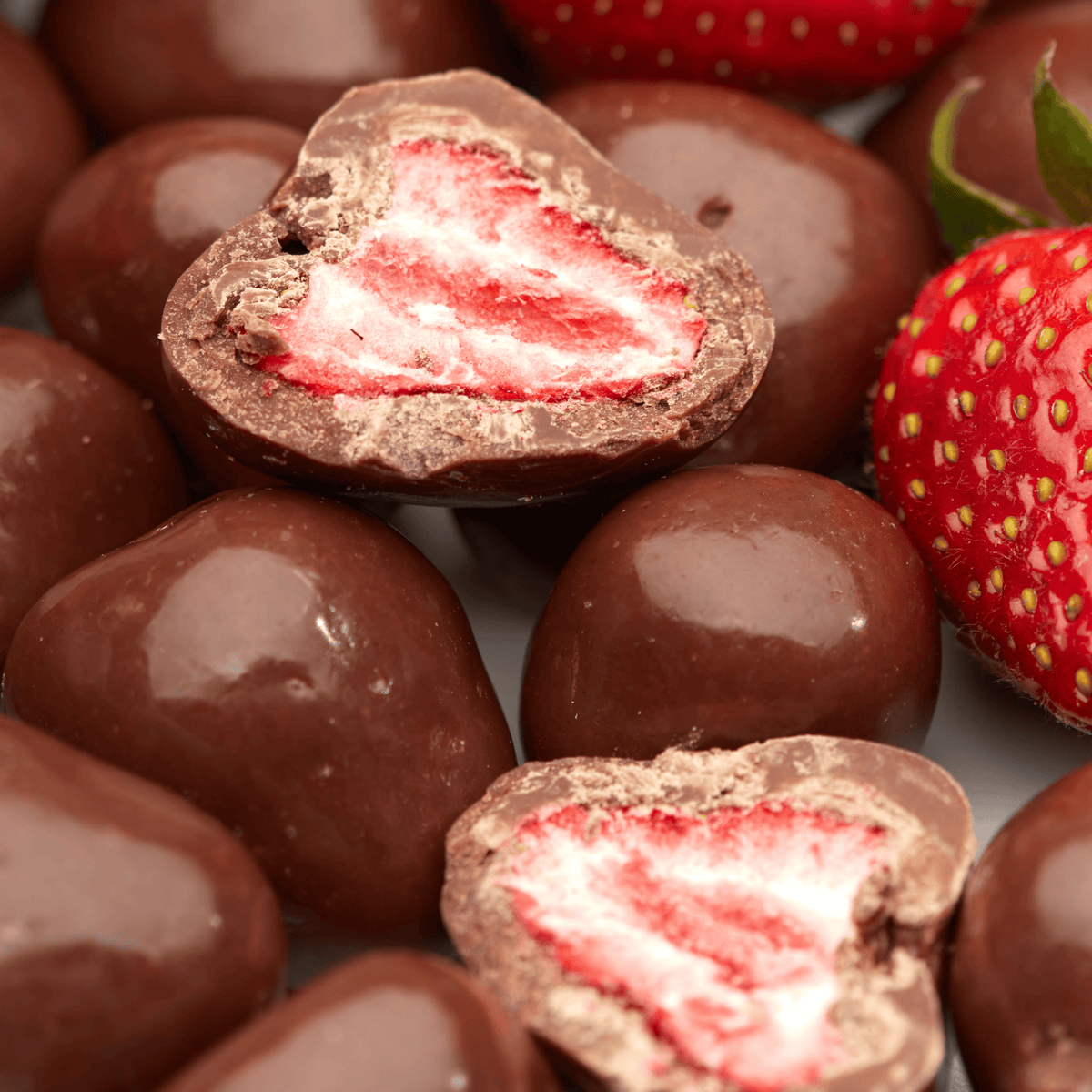 Geoeffnete NESSLIM Packung mit Erdbeeren in Vollmilchschokolade