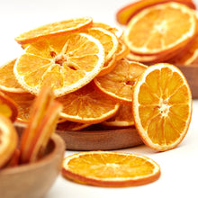 Naturbelassene getrocknete Orangenscheiben von NESSLIM in Holzschalen als aromatischer Zitrus-Snack.