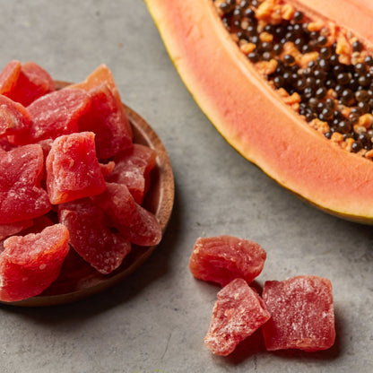 Papaya Chunks von Nesslim mit frischer Papaya als exotischer Trockenfrucht Snack auf grauem Untergrund
