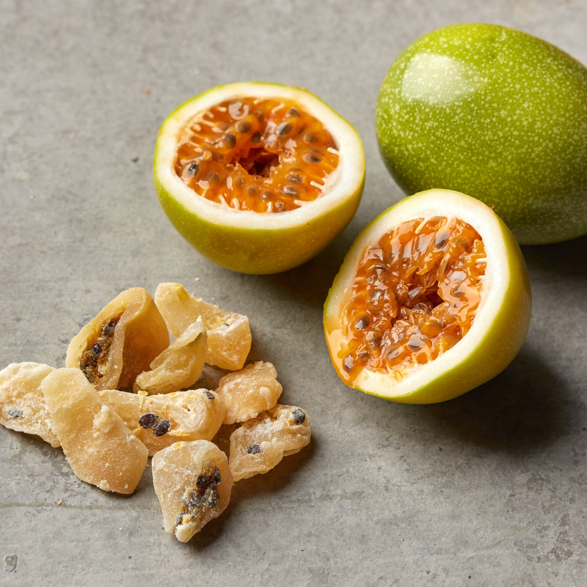 Getrocknete Passionsfruchtstücke von NESSLIM neben frischer Maracuja für Desserts und kreative Küche.