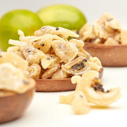 Getrocknete Passionsfruchtstücke von NESSLIM in Holzschalen als exotischer Maracuja-Snack mit intensivem Aroma.