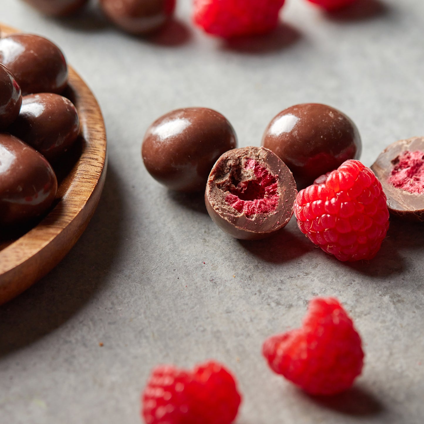 Geöffnete NESSLIM Packung mit Himbeeren in Vollmilchschokolade