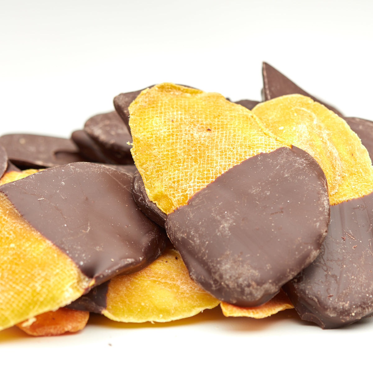 Schoko-Mangostreifen von NESSLIM neben einer frischen Mango, passend zu Kaffee oder als feiner Dessert-Snack.