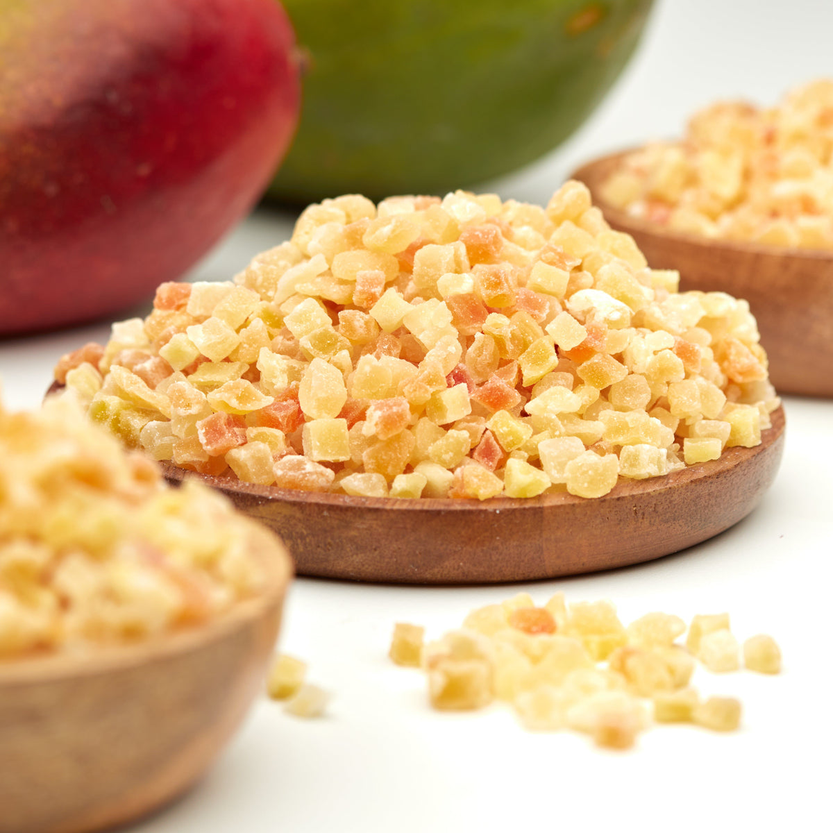 Gehackter Trockenfrucht-Mix von NESSLIM mit exotischen Fruchtstücken aus Ananas, Mango, Papaya und Melone in einer Holzschale.