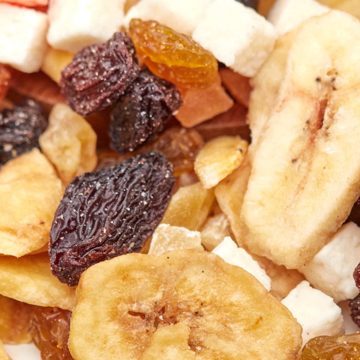 Makroaufnahme des Tropic Mix von NESSLIM mit Bananenchips, dunklen Rosinen und weißen Kokosstücken.