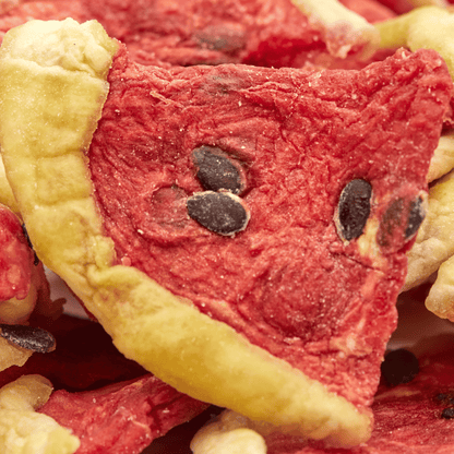 Makroaufnahme eines getrockneten Wassermelonenstücks im Pizzacut mit sichtbaren schwarzen Kernen.